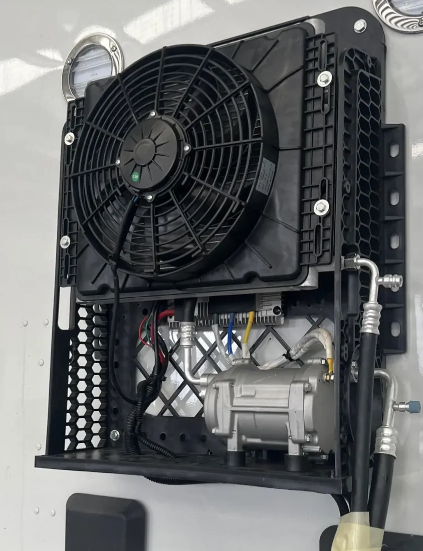 Compresor eléctrico 12V. Unidad externa por dentro: condensador, ventilador y control.